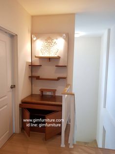 an empty room with a desk and shelves on the wall, next to a door