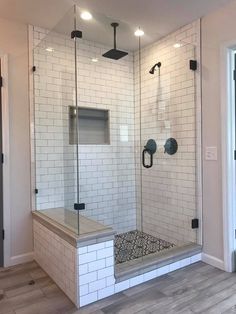 a walk in shower sitting inside of a bathroom next to a door and flooring