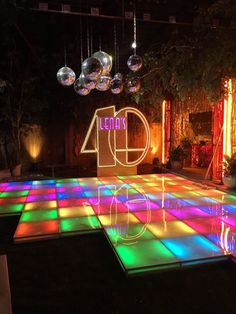 an illuminated dance floor with disco balls hanging from the ceiling