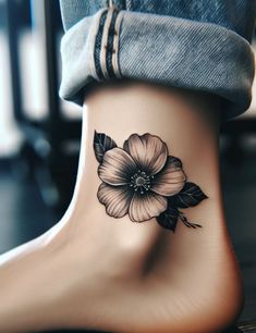 a woman's foot with a flower tattoo on the side of her ankle,