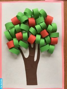 a tree made out of paper on top of a piece of paper with pink and green strips