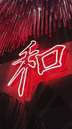 a red neon sign sitting on the side of a building