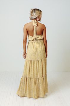 You are sure to feel nothing but happiness when you dress to impress in this beautiful primrose yellow colored maxi featuring lightweight flowy material patterned with a subtle floral print, a high neckline with a halter tie closure, ruffled trim detailing, a cinched waistline with a tie belt, and a relaxed tiered skirt silhouette that cascades into a straight ankle-length hemline! Yellow Flowy Halter Neck Dress, Flowy Yellow Halter Neck Dress, Yellow Floral Print Halter Neck Maxi Dress, Yellow Halter Neck Maxi Dress For Spring, Yellow Halter Maxi Dress For Summer, Bohemian Maxi Halter Dress For Garden Party, Bohemian Halter Maxi Dress For Garden Party, Yellow Halter Dress For Spring Vacation, Chic Yellow Halter Neck Maxi Dress