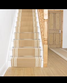 an empty staircase with beige carpet and white walls