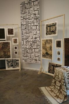 several pieces of art on display in a room with rugs and wall hangings