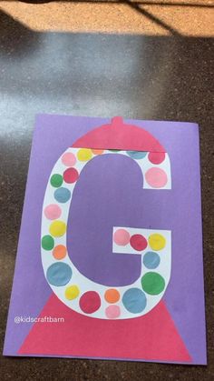 the letter g is made out of paper and has dots on it's edges