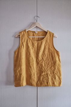 "A hard wearing everyday linen tank made in medium weight linen with French seams, a thin hem and an easy fit for simple natural style. Get them in every color. Pair with jeans or tuck into a high waist skirt, garden or go out with friends-- linen does it all. Approximate measurements below, but always choose your normal size for a relaxed fit or size down. Shoulder to hem 23\" for Small. Each size increased approximately 3/4\" in length. Petite US women's size 0,2,4 Small US Women's size 6,8,10 Linen Top Pattern, Find Style, Unusual Clothes, Modern Packaging, Girls Dress Sewing Patterns, Linen Tank Top, Summer Linen Dresses, Linen Tank, High Waist Skirt