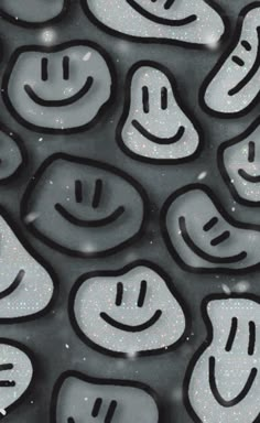 many smiley faces are drawn on the surface with black and white paint, as well as silver flecks