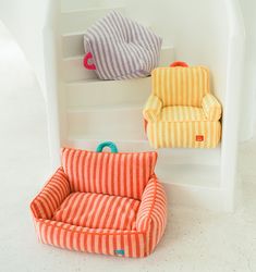 three colorful striped chairs sitting on top of a set of stairs next to each other