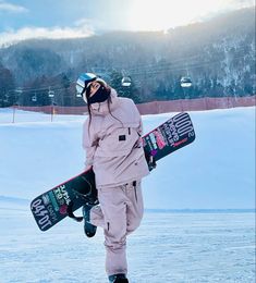 a snowboarder is walking in the snow with his board