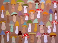 a group of different colored mushrooms on a piece of brown paper that has been cut out to look like they are smiling