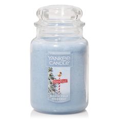 yankee candle jar filled with blue frosting and an image of a christmas tree on it