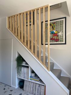 there is a stair case under the bannister in this house with bookshelves