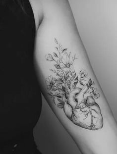 a black and white photo of a heart with flowers on it's left arm