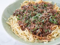 a plate of spaghetti with meat sauce and parsley