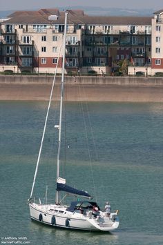 a sailboat in the water near some buildings