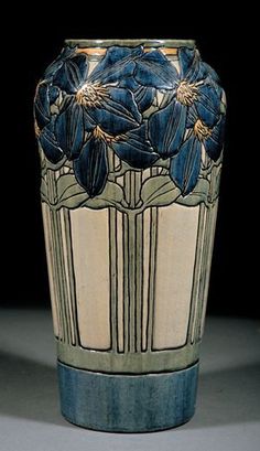 a blue and white vase with flowers on the outside, sitting against a black background