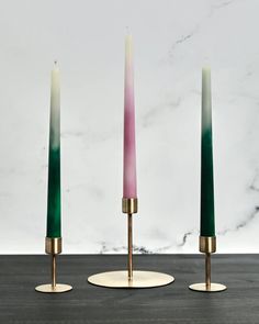 three candles sitting on top of a table next to each other