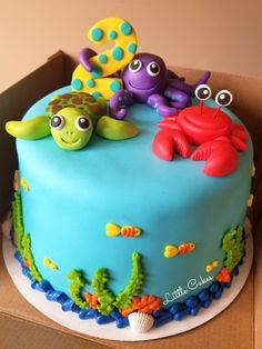 a blue cake decorated with sea animals and marine life on top of a cardboard box