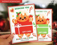 someone holding up two christmas cards with the words wishing you, gift card and sweet holidays