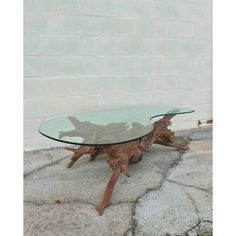 a glass table sitting on top of a stone floor next to a white brick wall