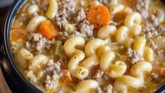 a bowl filled with pasta and meat soup