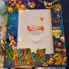 a mickey mouse photo frame with balloons and confetti