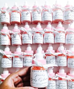 a person holding a bottle of hand sanitizer in front of a wall of bottles