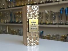 a wooden block with a sign that says thank you healthcare heroes on it in front of glass shelves