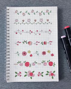 a notebook with flowers on it next to two pens