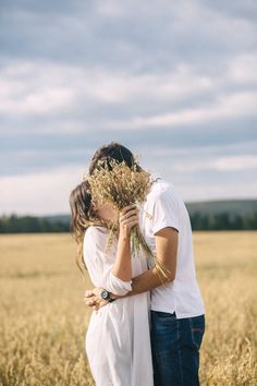 a man and woman kissing in a wheat field