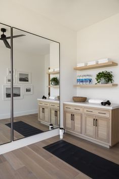 a bathroom with a large mirror and wooden cabinets