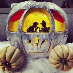 two pumpkins sitting next to each other in the snow with an artistic design on them