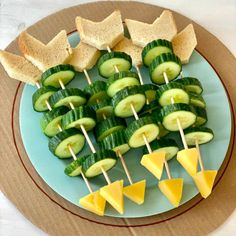 cucumber and cheese skewers are arranged on a plate with toothpicks