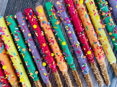 many colorful candles are lined up on a table with confetti and sprinkles