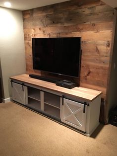 a flat screen tv sitting on top of a wooden entertainment center in a living room