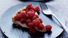 there is a piece of cake with raspberries on it and a fork next to it