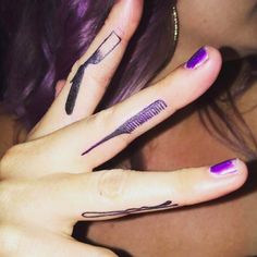 a woman with purple hair has two finger tattoos on her left and the other hand is holding