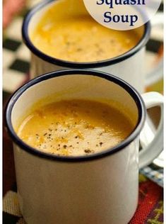 two white mugs filled with soup sitting on top of a table