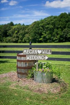 a wooden barrel sitting in the middle of a field with a sign that says vegan will wedding