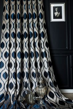 a black and white curtain with blue circles on it next to a silver candle holder