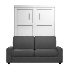 a gray couch sitting in front of a white wall with cupboards on it's sides