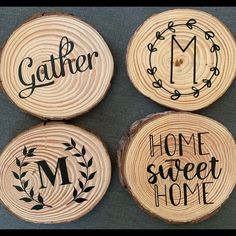 four wood slices with the words gather, home sweet home and m in black ink