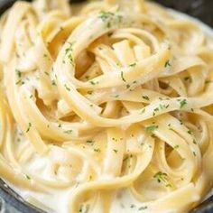 a bowl filled with pasta and sauce on top of a table