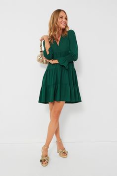 Meet one of our favorite silhouettes, the Crepe Kenzo Dress. Featuring feminine flutter smocked cuffs, a V-neckline, and a loose empire waist, this is the most flattering flirty frock! Pair this hunter green stunner with flats for a casual look or dress up with heels and statement earrings for date night. V-neckline Long sleeves Elasticated ruffle cuff Loose empire waist Tiered skirt Swing shape Mini length Crepe fabric Material: 97% Polyester, 3% Spandex Care: Machine wash cold Green V-neck Ruffle Dress, Green V-neck Ruffle Dress For Brunch, Elegant Green V-neck Ruffle Dress, Fitted V-neck Tiered Dress With Ruffle Hem, Green V-neck Dress With Ruffle Hem, Elegant V-neck Tiered Dress For Brunch, Elegant Flowy Tiered V-neck Dress, Elegant Flowy V-neck Tiered Dress, Green V-neck Spring Tiered Dress