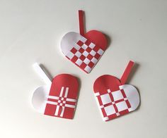 three pieces of paper cut out to look like heart shaped ornaments on a white surface