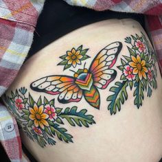 a woman's stomach with flowers and a butterfly tattoo on it