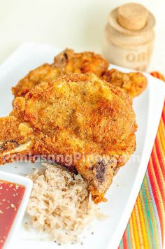 fried chicken with rice and sauce on a plate