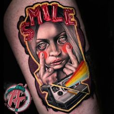 a tattoo with a woman's face and the word smile painted on her arm