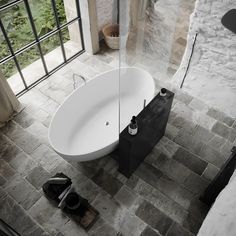 an aerial view of a bathtub in a bathroom with brick walls and flooring